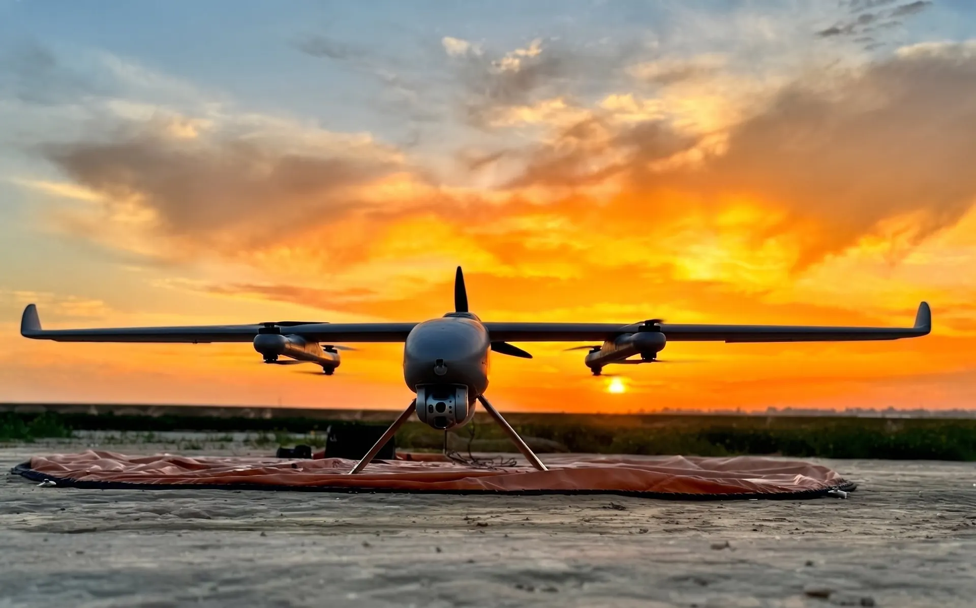 A VTOL aircraft on its landing pad at sunset